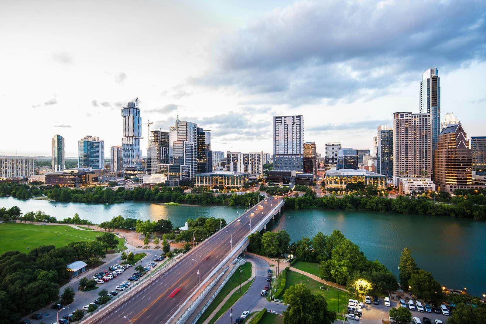 A downtown skyline across a river at dusk