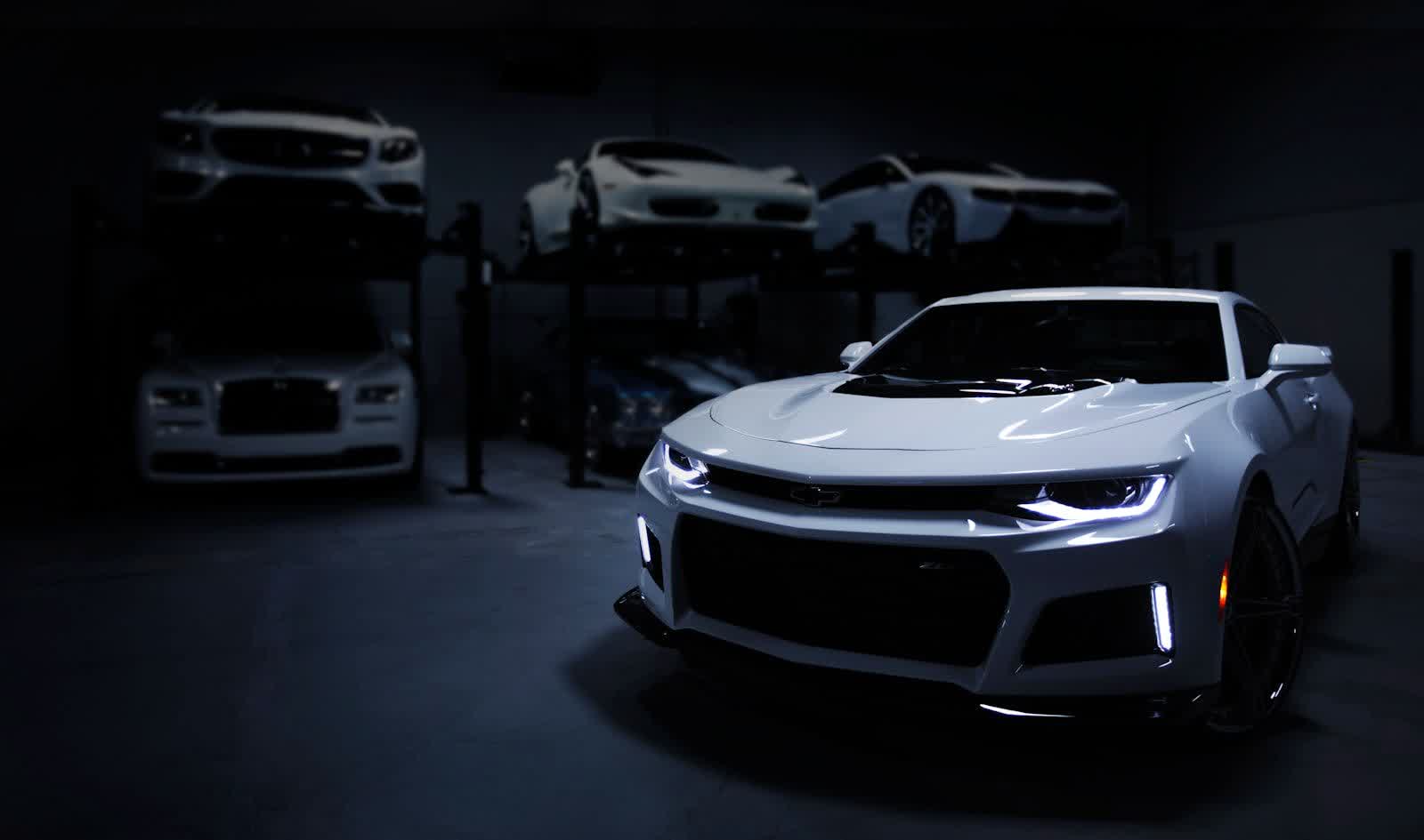 A finished car standing under even showroom light