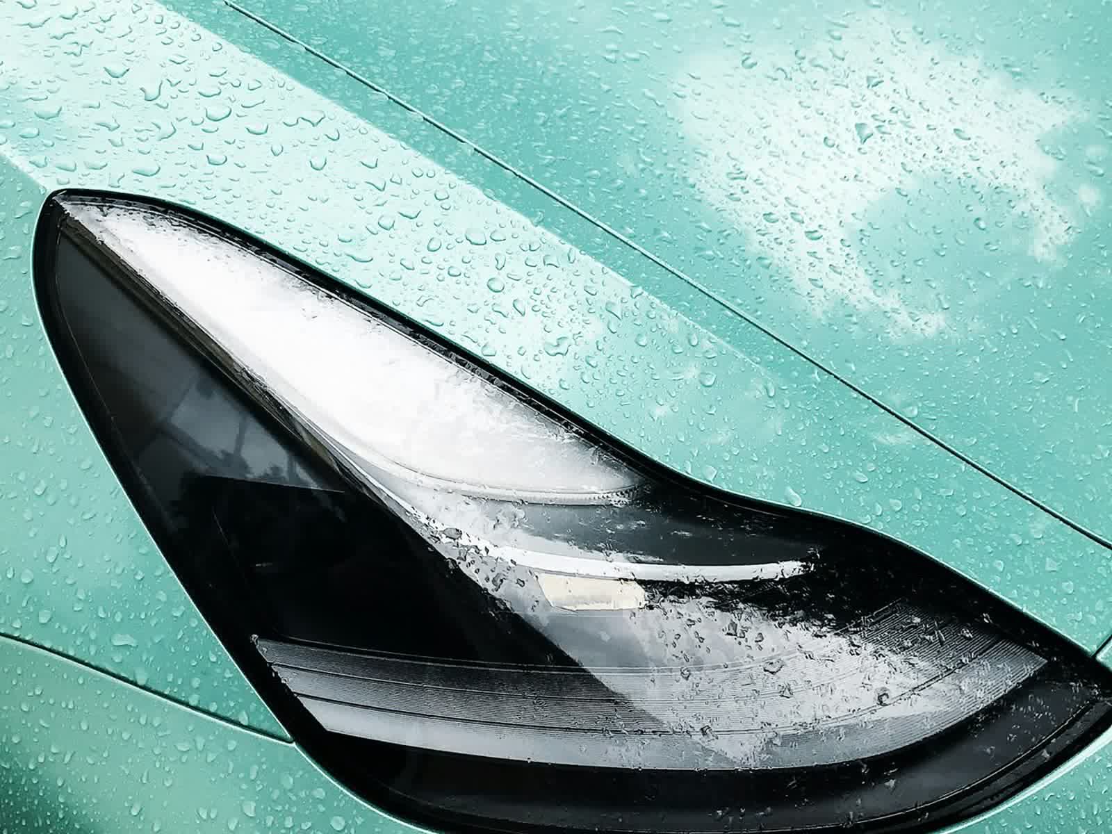 Water standing in tight beads across a coated panel beside a headlight