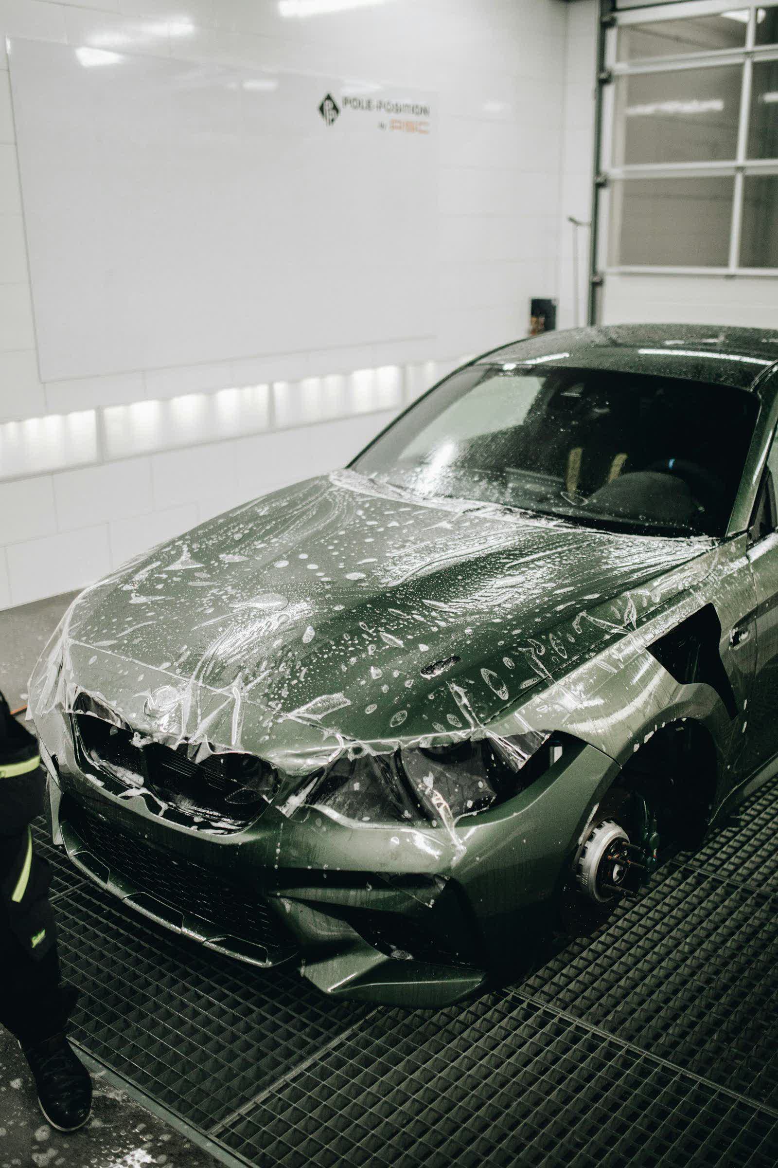 A car in the bay with protection film laid across its panels