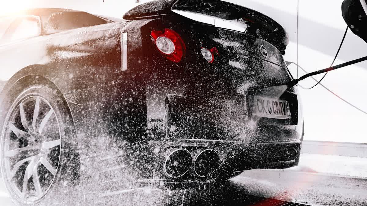 Two-bucket contact wash in progress on a wet car