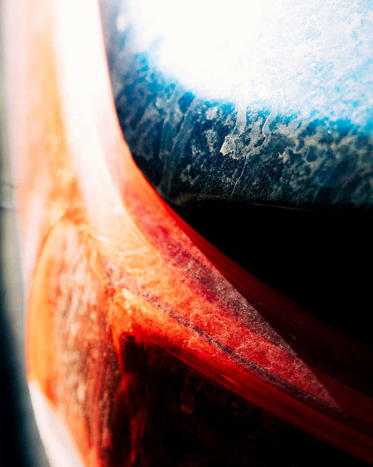 Macro of an orange panel where the clear coat has broken down and lifted