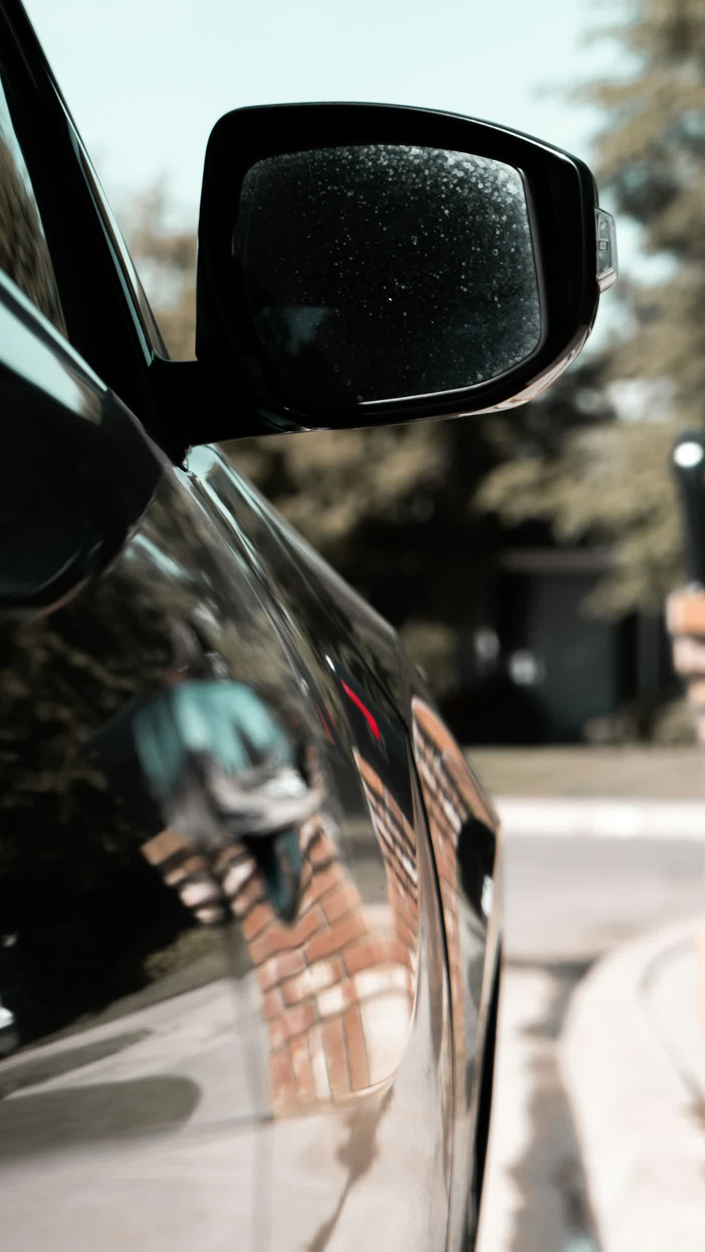 Water beading across a coated door and mirror in daylight